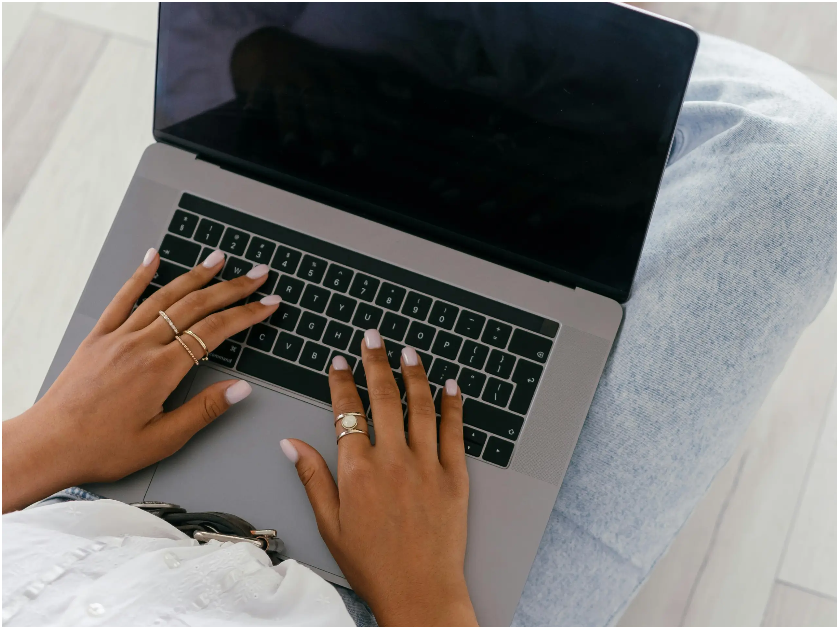 Top-down view of hands typing on a laptop keyboard